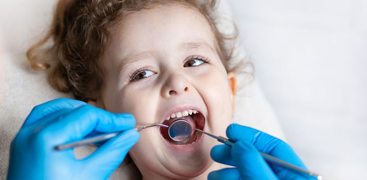 A young girl during a dentist exam.